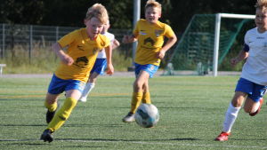 Frans Randström och Oskar Auvinen spelar i IIF Fotbolls P10-lag. Två spelare springer efter bollen på fotbollsplanen.