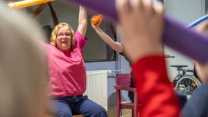Invånarna på Drumsö seniorhus hade tidigare stolgymnastik tre gånger i veckan, men den slopades eftersom gymnastiksalen behövdes som extra matsal. Arkivbild. Fysioterapeut ger instruktioner till äldre under stolgymnastiken.