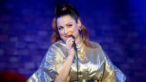 Erin laulaa kultainen mekko yllään.