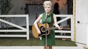 Dolly Parton kitara kädessä vuonna 1967. Arkistokuva, dokumenttisarjasta Countrymusiikki.