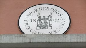 BSS räknar sina anor från 1892. En rund skylt, med texten Björneborgs svenska samskola 1892, är uppsatt på en tegelvägg.