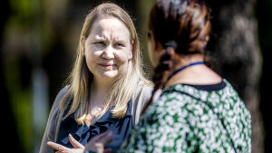 Arkivbild. Jutta Peltoniemi. Jutta Peltoniemi, en kvinna med blont hår, samtalar med Tiia Leino, en kvinna med brunt hår och mönstrad blus.