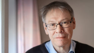 Åklagare Krister Petersson. Krister Petersson - åklagare och chef för Palmeutredningen. Han ser rakt in i kameran och har glasögon med svarta bågar.