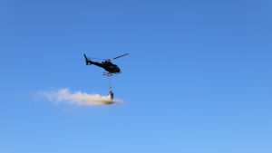 Det var viktigt att det inte blåste för mycket när kalkstenen spreds i viken. Helikopter sprider ut kalksten i Kolkkaviken i Nådendal.