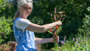 Blomsterhandlare Marianne Nordström gillar det vilda och naturliga i buketterna och anpassar dem varje gång enligt kundens önskemål och personlighet Kukkakauppias Marianne Nordström, Loviisa, kimppu kädessään