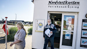 Ett par av de första tyska turisterna som anlände till Løkken på måndagsmorgonen. Løkken och Blokhus ett par mil längre söderut hör till de populäraste semesterorterna på Jylland. Två tyska turister utanför en turistbyrå i Løkken på västra Jylland.