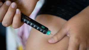 Forskning visar att fler diabetiker kunde bli friskare om de fick hjälp och stöd för att lägga om sin kost. Lapsi pistää insuliinia reiteen.