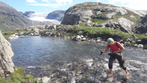 Räkna med att bli våt om fötterna ibland. En vandrare tar sig barfota över en fjällbäck.