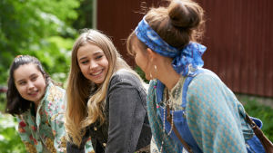 Linnea Skog spelar Jenna. Jenna (Linnea Skog) sitter tillsammans med vänner och de ser glada ut.