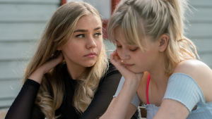 Jenna (Linnea Skog) och Alisa Röyttä. Närbild på Jenna (Linnea Skog) som sitter tillsammans med en annan ung kvinna (Alisa Röyttä).