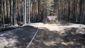 Den avlägsna brandplatsen har försvårat släckningsarbetet. Palomies ajaa mönkijällä palaneen metsän keskellä.