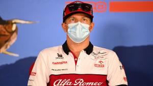 Kimi Räikkönen blickar uppåt med munskydd på sig.