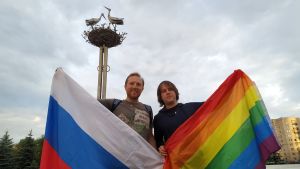 Aleksej Nazarov och kollegan Aleksej Sergejev demonstrerar för lika rättigheter. En man står och håller i en Rysslandflagga och en annan man lyfter upp regnbågsflaggan.