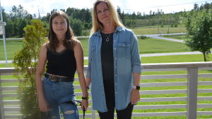 (Anna och Agnes Påfs trivs i Maxmo. En kvinna, en flicka och en hund på en terass.