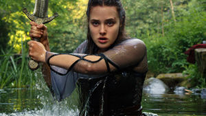 Katherine Langford känd från tv-serien "13 Reasons Why" spelar Nimue - den kvinnliga gestalt ur vilken historien om Kung Arthur är berättad den här gången. Katherine Langford i rollen som Nimue i tv-serien "Cursed". På bilden har hon vatten upp till midjan och håller i ett svärd