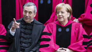 Harvards styrelseordförande Lawrence Bacow med Angela Merkel vid examensceremonin år 2019. Harvards styrelseordförande Lawrence Bacow med Angela Merkel vid examensceremonin år 2019.