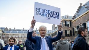 Den euroskeptiska oppositionen utmanar Ruttes regering. Här demonstrerar högerpopulisten Geert Wilders i samband med Giuseppe Contes besök i Haag. Euroskeptiska politikern Geert Wilders demonstrerar i samband med italienska premiärministern Mark Ruttes besök i Haag. I handen har han en skylt där det står: inte en cent mer till Italien.