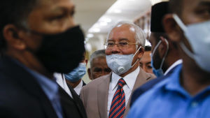Najib bar sitt munskydd på sned då han lämnade domstolen i Kuala Lumpur. Najib bar sitt munskydd på snedd då han lämnade domstolen i Kuala Lumpur.