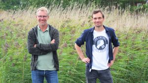 Biträdande professor i miljö- och marinbiologi vid Åbo Akademi, Christoffer Boström, och doktorand i miljö- och marinbiologi, Lukas Meysick. Två män står på en brygga med vass i bakgrunden.