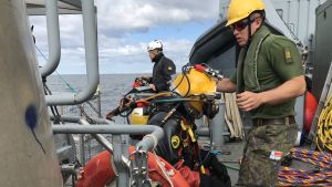 Marinens dykare dök ner till vraken flera gånger om dagen. Marinens dykare på väg i vattnet för att utföra oljesaneringsarbete.