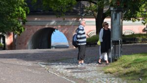 Enstaka turister har hittat till Sveaborg under en vardagsmorgon i augusti. Turister titta på en karta på Sveaborg.