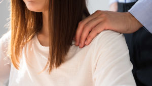 För "Louise" började det med lätt beröring och slutade med hotelser. (Kvinnan på bilden är inte Louise.) En man sätter sin hand på en kvinnas axel.