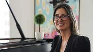 USA går samma väg som Venezuela om demokraterna vinner valet, menar Andreina Kissane. Andreina Kissane i Miami hemma vid flygeln i sin bostad. Hon stöder Donald Trump i valet 2020.