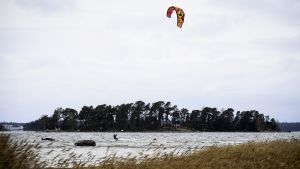 n kitesurfare i Helsingfors tog vara på det blåsiga vädret. En person som kitesurfar i Helsingfors.