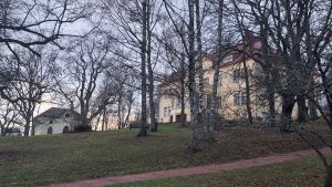Många Sibbobor har aldrig besökt gårdens karaktärsbyggnad, utan bara flanerat i trädgården. Gräddgul herrgård i en trädgård på hösten.