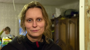 Henna Kapanen anser att kommunen borde ta särskild hänsyn till att sonen Roni har en funktionsnedsättning och utgå ifrån vad som är bäst för barnet. Kvinna i svart tröja tittar in i kameran.