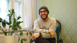 "Jag vill säga till de som är från den muslimska HBTQ+ gemenskapen att du inte är ensam" - Hassen. Hassen, sitter i en stol. På bilden ser han mot kameran och ler.
