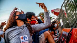 Demonstrationer har brutit ut i Brasilien efter att en svart man dödades av vita säkerhetsvakter i en mataffär i staden Porto Alegre. Bilden är tagen utanför affären där mannen dog Demonstration i Porto Alegre 20.11.2020. En kvinna i munskydd håller upp sitt mittfinger.