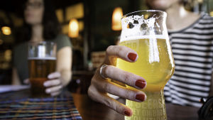 Ölen flödar ännu i kranarna på barer och restauranger. Två personer dricker öl i en restaurang.