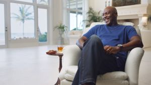 Dokumentärserien om basketstjärnan Michael Jordan är beroendeframkallande. Michael Jordan sitter i en fotölj och skrattar, med ett whiskeyglas bredvid sig.