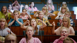 Lasten tasavallan kansanedustajia eduskuntatalon istuntosalissa. Lapsia eduskuntatalon istuntosalissa.