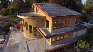 Cannabis, eller hampa, kan användas som byggmaterial genom att blanda det med till exempel sand. Det amerikanska huset på bilden är gjort av så kallad hempcrete, en hamp-cement. Bild på gult och träfärgat hus med solpaneler på taket.