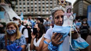 En kvinna demonstrerar mot lagförslaget som vill legalisera abort i Argentina. Abortmotståndarna klär sig ofta i ljusblått. En kvinna som demonstrerar i de argentinska abortmotståndarnas ljusblå färger håller upp en liten staty av junfru Maria.