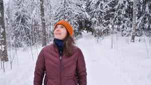 "Är det där en hackspett?" utbrister Tanja Korvenmaa, som gillar att titta på fåglar. En kvinna som står på en väg och tittar upp mot träden.