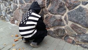 Kristian har fått många möjligheter men inte förmått använda dem. Ung kille med ryggen mot kameran vid stenvägg.
