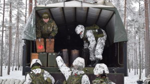 En lastbil kom packad med stormlyktor. Rekryter packar stormlyktor ur en lastbil inför en övernattning i Galoppskogen utanför Ekenäs.