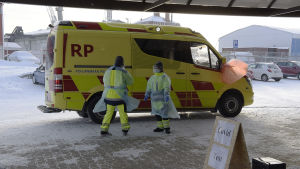 Provtagningen ordnas i en ambulans. Ambulans och personal vid en covid provtagning