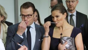 Kruununprinsessa Victoria and Prinssi Daniel syövät lusikoilla jotain juhlissa.