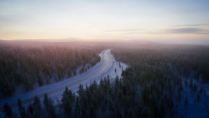 Dronekuva tiestä ja metsästä sekä horisontista Lapissa