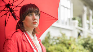 Litku Klemetti ulkona punaisen sateenvarjon alla
