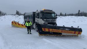 Snön från Jakobstads centrum förs till en plats öster om centrum, dit Kent Allén och hans kollegor kör i skytteltrafik. En man med arbetskläder står intill en stor plogbil i snön