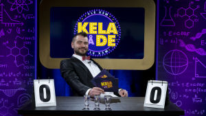 Programledaren Hannes, eller ... Daddy? En man sitter i en tävlingsstudio och i bakgrunden står det "Kela på de".