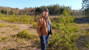 Jari Korkki står med ryggen mot motorvägen. Här vill Pyttis ha vildmarks- och naturkulturmuseet. En man på en tom tomt.