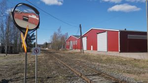 Kemikalier transporteras med tåg, fartyg och långtradare. Plankorsning med varningsspegel för biltrafiken.