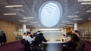 Helsingfors universitets bibliotek. Studerande sitter och studerar i Helsingfors universitets huvudbibliotek.