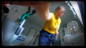 Piilokameralla kuvattu kuva, jossa hoitaja kurottaa kameraa. Kasvot on pikselöity.